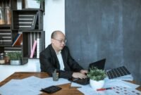 Seorang pengusaha UMKM Indonesia sedang serius menganalisis data pemasaran digital di laptopnya, menunjukkan dedikasi dalam mengembangkan strategi penjualan online yang efektif. Foto ini menggambarkan semangat adaptasi bisnis lokal terhadap era digital untuk meraih pasar yang lebih luas.