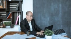 Seorang pengusaha UMKM Indonesia sedang serius menganalisis data pemasaran digital di laptopnya, menunjukkan dedikasi dalam mengembangkan strategi penjualan online yang efektif. Foto ini menggambarkan semangat adaptasi bisnis lokal terhadap era digital untuk meraih pasar yang lebih luas.