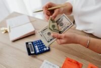 Seorang pemilik usaha kecil sedang serius menghitung laporan keuangan, menunjukkan pentingnya pencatatan detail untuk memahami kondisi finansial bisnis. Pengelolaan keuangan yang cermat adalah kunci keberlanjutan setiap UMKM.