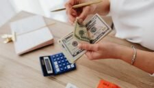 Seorang pemilik usaha kecil sedang serius menghitung laporan keuangan, menunjukkan pentingnya pencatatan detail untuk memahami kondisi finansial bisnis. Pengelolaan keuangan yang cermat adalah kunci keberlanjutan setiap UMKM.