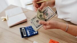 Seorang pemilik usaha kecil sedang serius menghitung laporan keuangan, menunjukkan pentingnya pencatatan detail untuk memahami kondisi finansial bisnis. Pengelolaan keuangan yang cermat adalah kunci keberlanjutan setiap UMKM.