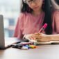 Seorang wirausahawan muda tampak fokus bekerja dengan laptop di meja kerja rumahnya, melambangkan semangat memulai bisnis dengan memanfaatkan teknologi dan sumber daya pribadi. Suasana yang nyaman mencerminkan fleksibilitas dalam mengelola usaha rintisan.