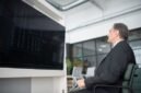 Gambar menunjukkan seorang profesional yang sedang menganalisis data di depan layar komputer yang menampilkan berbagai grafik, melambangkan kompleksitas dan pentingnya strategi bisnis digital berbasis data. Ini menggambarkan bagaimana perusahaan modern memanfaatkan teknologi untuk memahami tren pasar dan perilaku konsumen.