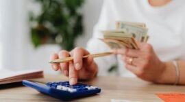 Seorang pemilik UMKM dengan serius menghitung laporan keuangan, menunjukkan komitmen terhadap pengelolaan finansial yang cermat demi keberlanjutan usahanya. Setiap angka yang dicatat adalah cerminan dari potensi pertumbuhan bisnis di masa depan.