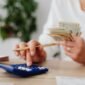 Seorang pemilik UMKM dengan serius menghitung laporan keuangan, menunjukkan komitmen terhadap pengelolaan finansial yang cermat demi keberlanjutan usahanya. Setiap angka yang dicatat adalah cerminan dari potensi pertumbuhan bisnis di masa depan.