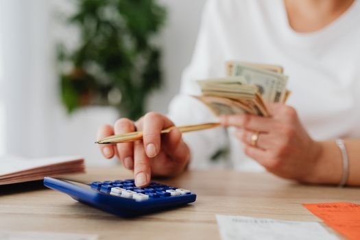 Seorang pemilik UMKM dengan serius menghitung laporan keuangan, menunjukkan komitmen terhadap pengelolaan finansial yang cermat demi keberlanjutan usahanya. Setiap angka yang dicatat adalah cerminan dari potensi pertumbuhan bisnis di masa depan.