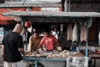 Seorang pebisnis wanita sedang menganalisis data dan grafik, menunjukkan fokus pada pemahaman mendalam tentang target pasar lokal untuk mengembangkan strategi bisnis yang efektif. Gambar ini menggambarkan pentingnya riset dan adaptasi dalam menghadapi dinamika pasar Indonesia.