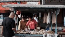 Seorang pebisnis wanita sedang menganalisis data dan grafik, menunjukkan fokus pada pemahaman mendalam tentang target pasar lokal untuk mengembangkan strategi bisnis yang efektif. Gambar ini menggambarkan pentingnya riset dan adaptasi dalam menghadapi dinamika pasar Indonesia.