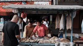 Seorang pebisnis wanita sedang menganalisis data dan grafik, menunjukkan fokus pada pemahaman mendalam tentang target pasar lokal untuk mengembangkan strategi bisnis yang efektif. Gambar ini menggambarkan pentingnya riset dan adaptasi dalam menghadapi dinamika pasar Indonesia.