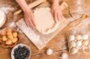 Seorang wanita sedang bekerja di meja dapur yang tertata rapi, dikelilingi oleh peralatan memasak dan bahan kerajinan, menggambarkan suasana produktif di rumah. Gambar ini merepresentasikan berbagai potensi usaha yang dapat dikembangkan dari rumah sendiri.