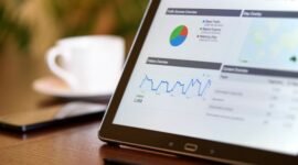 Ilustrasi menunjukkan berbagai elemen strategi bisnis digital, seperti grafik pertumbuhan, ikon media sosial, dan tim yang sedang menganalisis data, menggambarkan kompleksitas dan sinergi yang dibutuhkan untuk sukses di ranah online. Gambar ini mewakili perencanaan dan eksekusi yang cermat dalam mencapai tujuan bisnis digital.