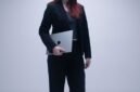 Seorang perempuan tersenyum di depan laptop, simbol kemudahan pendaftaran NIB secara daring yang kini bisa dilakukan siapa saja dari mana saja. Proses digital ini membantu pelaku usaha mikro dan kecil mendapatkan legalitas dengan cepat.