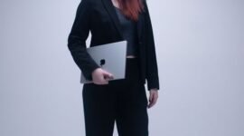 Seorang perempuan tersenyum di depan laptop, simbol kemudahan pendaftaran NIB secara daring yang kini bisa dilakukan siapa saja dari mana saja. Proses digital ini membantu pelaku usaha mikro dan kecil mendapatkan legalitas dengan cepat.