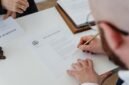 Seseorang sedang mengisi formulir pendaftaran secara daring di laptop, menunjukkan kemudahan proses digitalisasi dalam mengurus Nomor Induk Berusaha (NIB) yang menjadi fondasi legalitas bisnis. Dokumen digital di layar melambangkan era baru perizinan usaha yang lebih efisien dan modern.