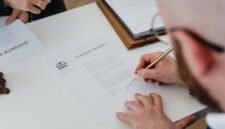 Seseorang sedang mengisi formulir pendaftaran secara daring di laptop, menunjukkan kemudahan proses digitalisasi dalam mengurus Nomor Induk Berusaha (NIB) yang menjadi fondasi legalitas bisnis. Dokumen digital di layar melambangkan era baru perizinan usaha yang lebih efisien dan modern.