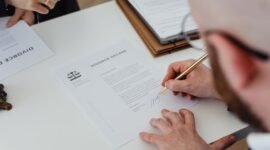 Seseorang sedang mengisi formulir pendaftaran secara daring di laptop, menunjukkan kemudahan proses digitalisasi dalam mengurus Nomor Induk Berusaha (NIB) yang menjadi fondasi legalitas bisnis. Dokumen digital di layar melambangkan era baru perizinan usaha yang lebih efisien dan modern.