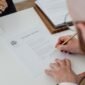 Seseorang sedang mengisi formulir pendaftaran secara daring di laptop, menunjukkan kemudahan proses digitalisasi dalam mengurus Nomor Induk Berusaha (NIB) yang menjadi fondasi legalitas bisnis. Dokumen digital di layar melambangkan era baru perizinan usaha yang lebih efisien dan modern.