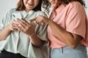 Sekelompok orang dari berbagai latar belakang etnis dan usia terlihat antusias berinteraksi melalui layar perangkat digital mereka, menggambarkan bagaimana media sosial memperkuat koneksi dan kolaborasi di era modern. Gambar ini mewakili keberagaman dan dinamika interaksi positif yang bisa terjalin melalui platform daring.