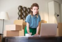 Seorang wanita tengah fokus bekerja di meja kerjanya yang tertata rapi di rumah, dikelilingi oleh berbagai peralatan seperti laptop, buku, dan beberapa dekorasi tanaman yang menunjukkan suasana kantor rumahan yang nyaman dan produktif. Ia sedang menjalankan salah satu ide usaha rumahan kreatif yang memungkinkannya mengelola bisnis dari kenyamanan rumah sendiri.