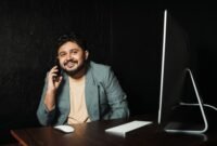 Seorang wirausahawan muda tersenyum di depan laptopnya, merefleksikan semangat dan kreativitas yang dibutuhkan untuk membangun bisnis dari nol dengan memanfaatkan teknologi. Gambar ini menunjukkan bahwa kesuksesan bukan hanya milik mereka yang bermodal besar, melainkan juga mereka yang gigih dan cerdas dalam memanfaatkan peluang.