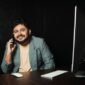 Seorang wirausahawan muda tersenyum di depan laptopnya, merefleksikan semangat dan kreativitas yang dibutuhkan untuk membangun bisnis dari nol dengan memanfaatkan teknologi. Gambar ini menunjukkan bahwa kesuksesan bukan hanya milik mereka yang bermodal besar, melainkan juga mereka yang gigih dan cerdas dalam memanfaatkan peluang.