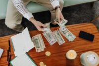 Seorang wanita tengah menghitung tumpukan koin yang dikumpulkan dalam toples, melambangkan upaya menabung secara konsisten untuk modal awal sebuah usaha. Gambar ini merefleksikan semangat wirausaha dalam mengelola keuangan pribadi.
