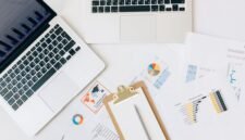 Seorang pebisnis wanita profesional tampak menganalisis data grafik pada layar tabletnya, menggambarkan proses pengambilan keputusan berbasis data yang krusial dalam strategi bisnis digital. Di latar belakang, terlihat elemen visual yang merepresentasikan konektivitas global dan pertumbuhan digital.