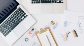 Seorang pebisnis wanita profesional tampak menganalisis data grafik pada layar tabletnya, menggambarkan proses pengambilan keputusan berbasis data yang krusial dalam strategi bisnis digital. Di latar belakang, terlihat elemen visual yang merepresentasikan konektivitas global dan pertumbuhan digital.