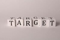 Gambar ini menunjukkan sebuah anak panah yang menancap tepat di tengah papan dartboard, melambangkan akurasi dalam membidik target pasar yang spesifik. Ilustrasi visual ini merepresentasikan pentingnya fokus dalam strategi pemasaran untuk mencapai keberhasilan bisnis yang optimal.